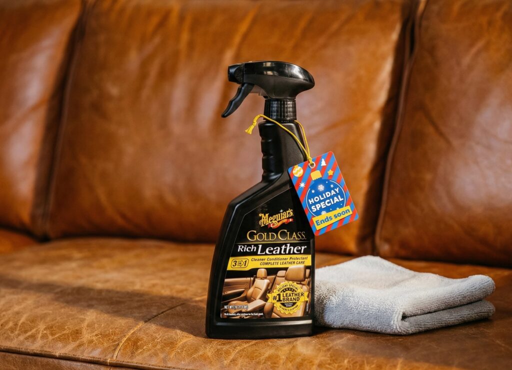 Meguiar's Gold Class Rich Leather Cleaner and Conditioner 3-in-1 Spray bottle with a microfiber towel on a tan leather sofa for home furniture maintenance.