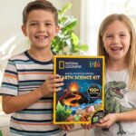 Two American children excitedly exploring colorful gemstones and natural crystals from a National Geographic Earth Science Kit, engaging in a hands-on STEM learning activity at home.
